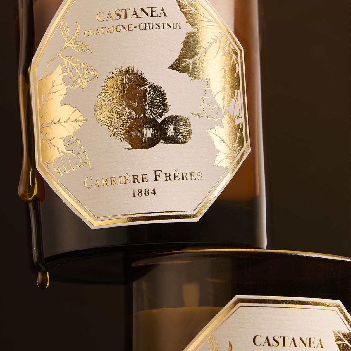 A close up shot of Carrière Frères Chestnut Scented Candle in a brown-tinted glass jar with botanical label.
