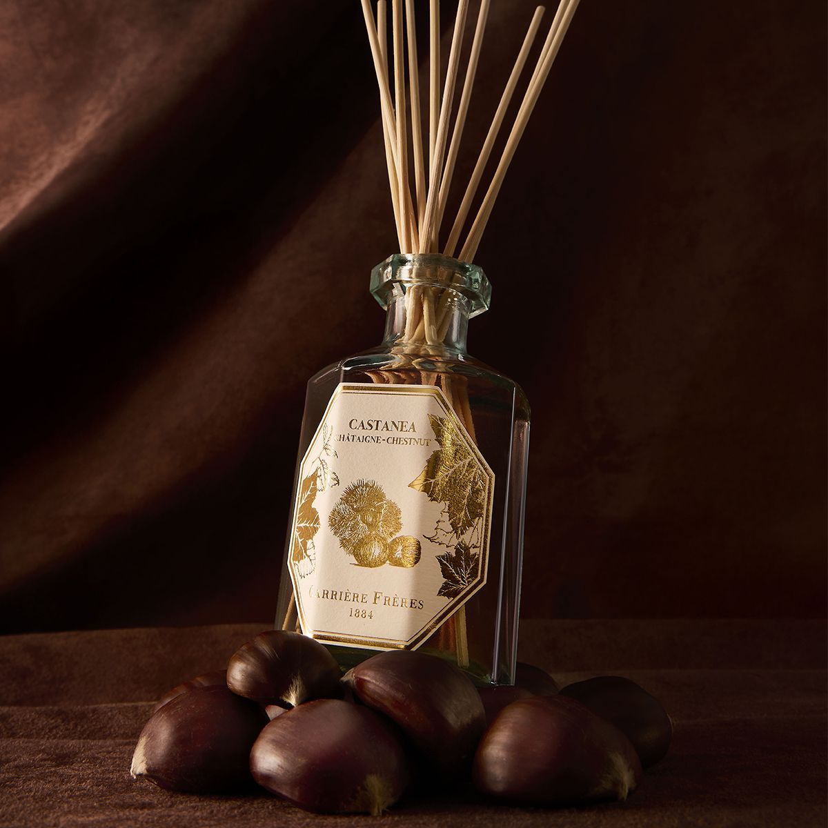 Carrière Frères Chestnut Diffuser in a recycled glass bottle with natural rattan sticks.