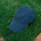 HÔTEL827 Sun Kissed blue baseball cap on the grass.