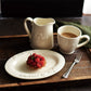 Studio M' Creamware Latte Mug in a warm cream ceramic glaze, in a table setting serving table and paired with other creamware items. 