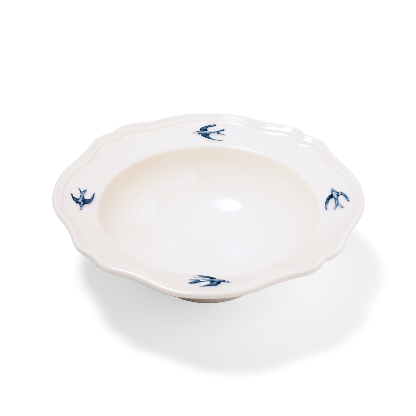 Studio M' Early Bird 170 porcelain bowl featuring a hand-painted blue swallow relief on a scalloped floral rim. A shot taken from the side angle. 