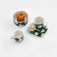 A lifestyle shot of the Marimekko Oiva collection featuring the iconic Unikko poppy print in dark green, beige, and light sand.