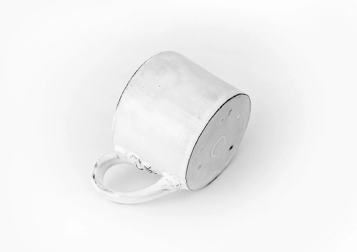 A side shot of Carron Paris ceramic mug with a signature small embossed knot.