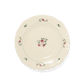 A pack shot of Studio M' Rosier Plate 16.5cm in a warm, subtle beige glaze, featuring a vintage-inspired red rose motif and an elegantly tiered, hand-painted rim.